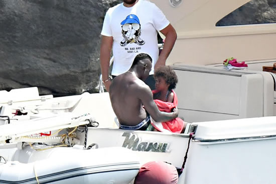 Snapped: Mario Balotelli relaxes on yacht with daughter – and two brunette beauties
